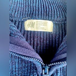 Blue ribbed sweater with brown & blue plaid slacks.